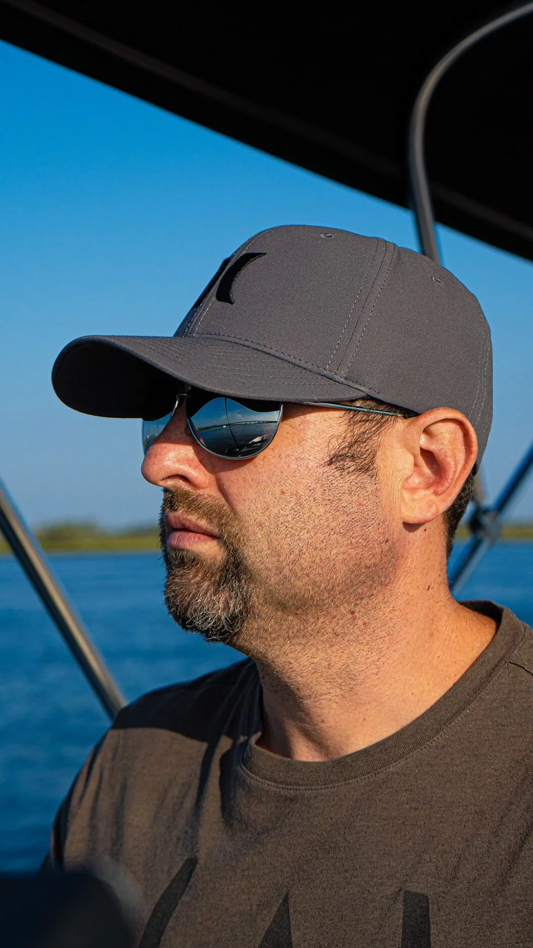 A man wearing sunglasses and a hat on a boat.